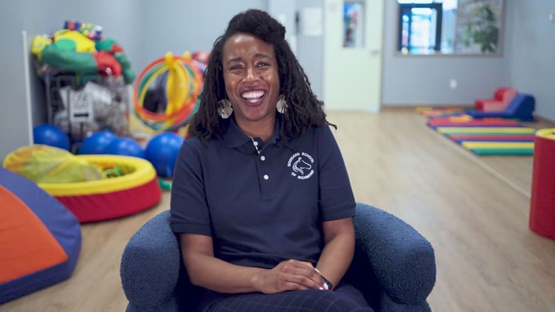 An early-childhood educator interviewed in a colorful playroom.
